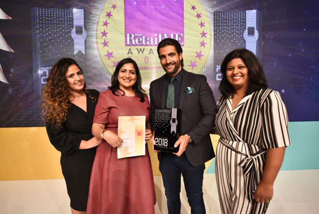 A man and a woman holding awards and a woman next to each of them