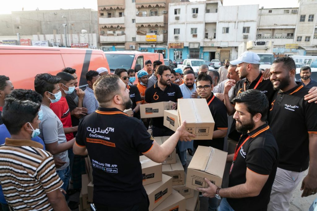 A group of 6th Street.com employees hand out food boxes in Ramadan