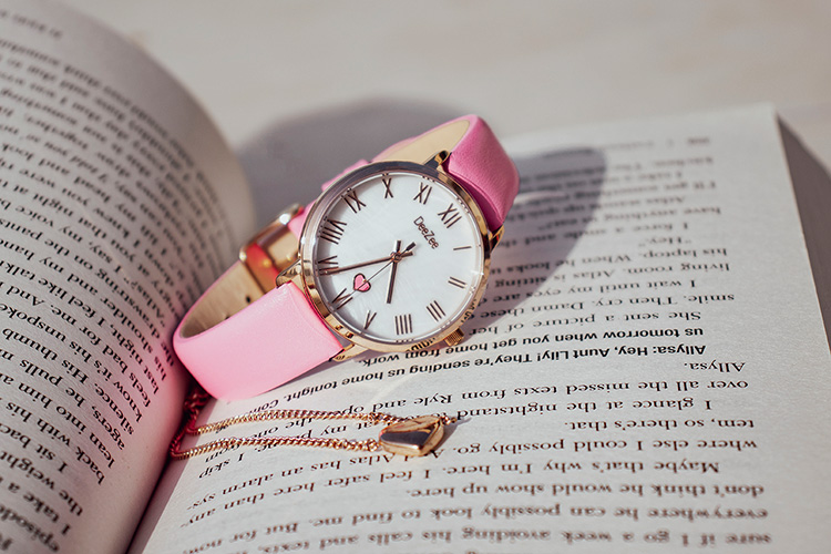 CCC pink watch with a necklace inside an open book