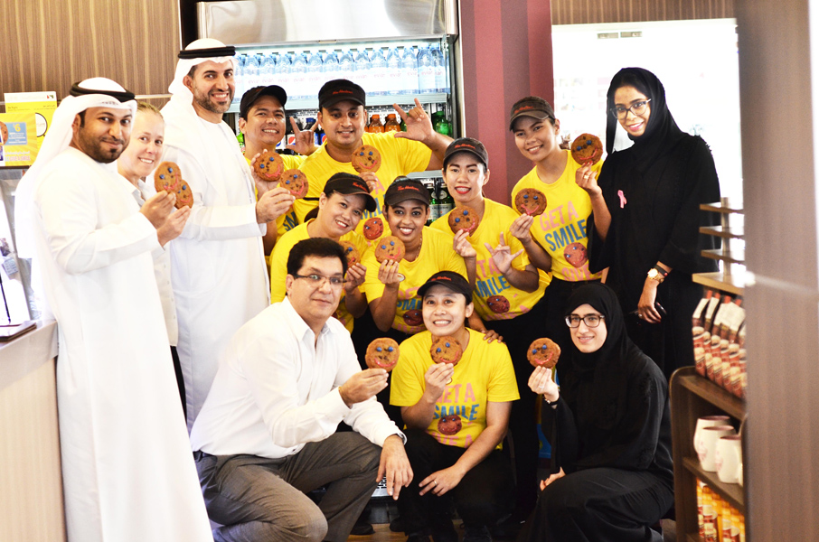 A group of workers holding smile cookies