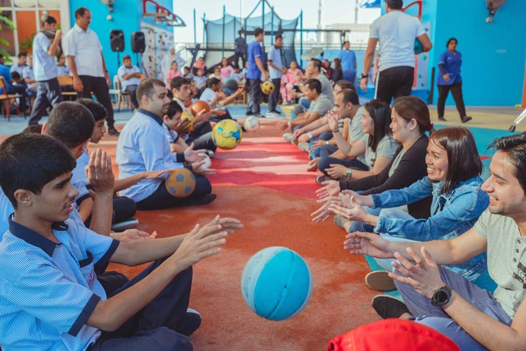 A group of people sitting and playing with balls