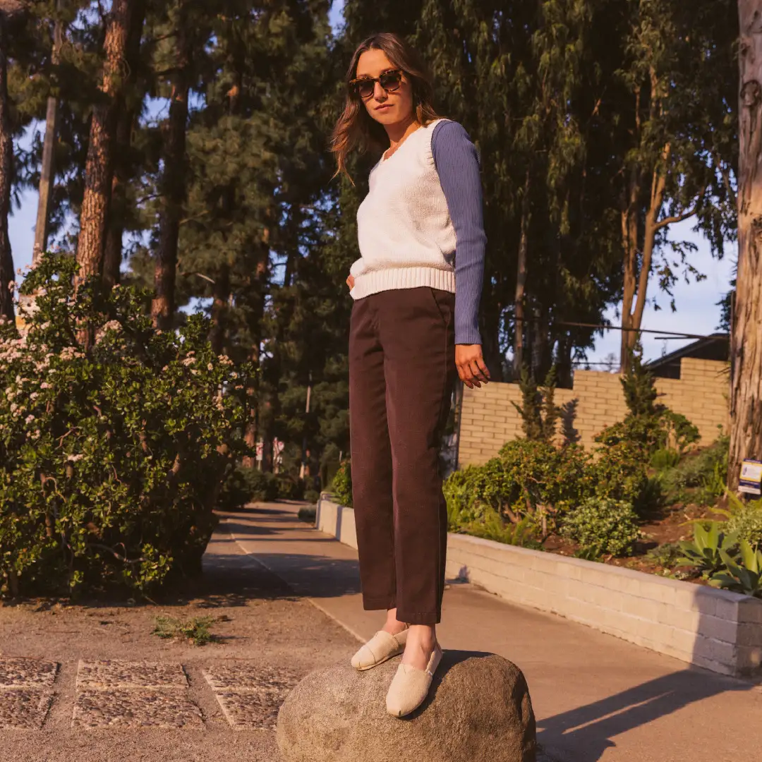 Woman standing on a rock in TOMS footwear