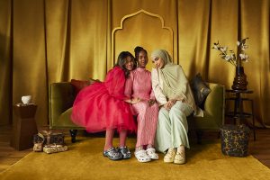 three women wearing crocs shoes and sitting on the sofa