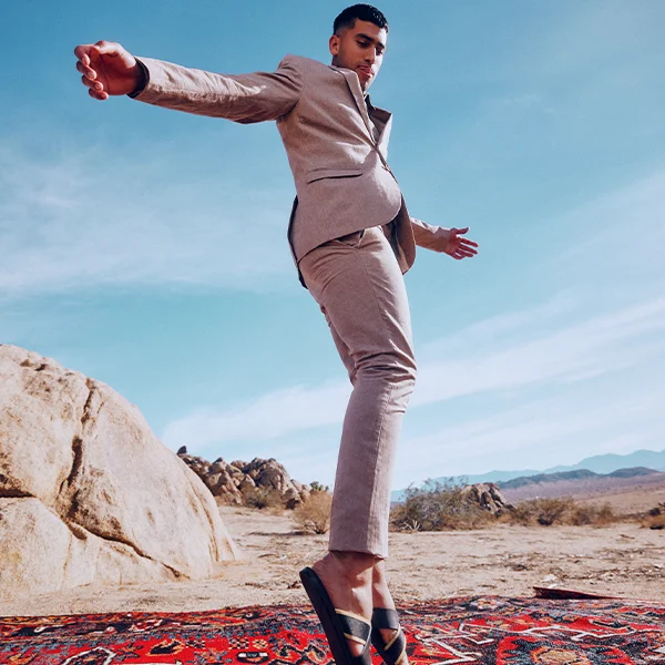 A man in the desert wearing vegan slippers from Call It Spring