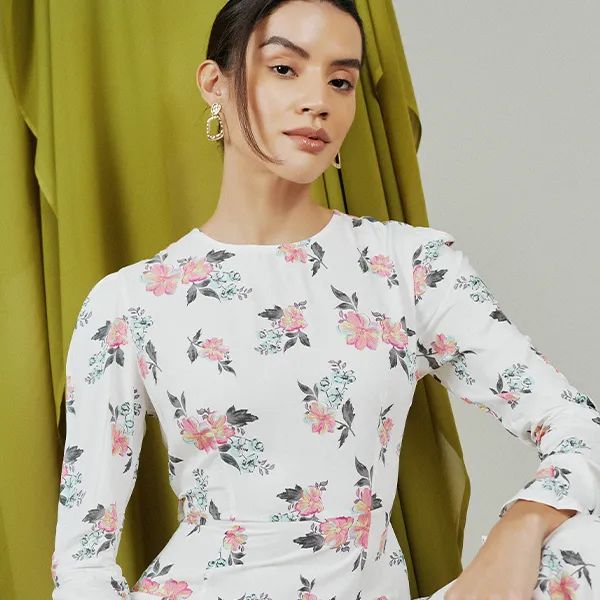 A woman wearing a white floral dress from His & Hers