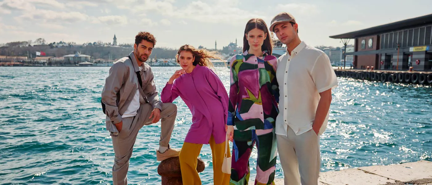 Two men and two women standing by water, modeling LC Waikiki fashion